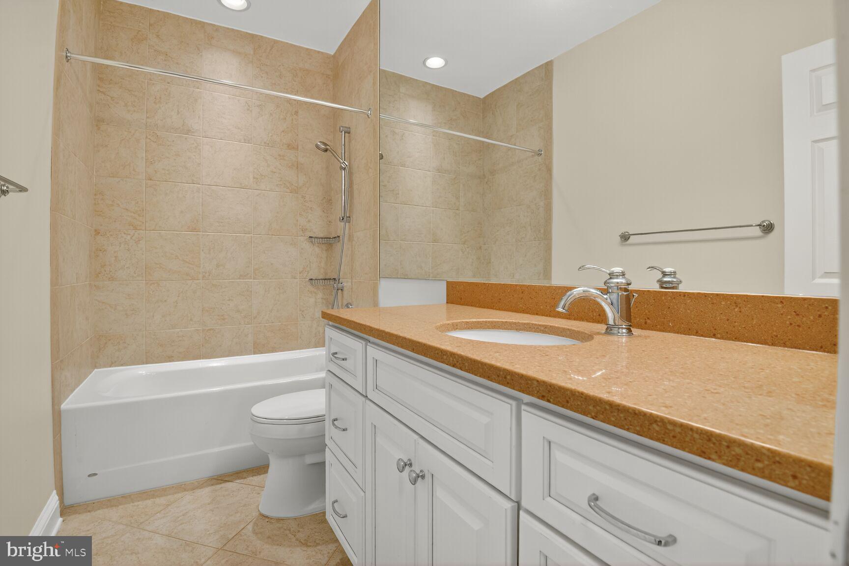 11405 Summer House Court Reston, VA 20194 - Photo 11 of 20 a bathroom with a granite countertop sink a toilet and bathtub