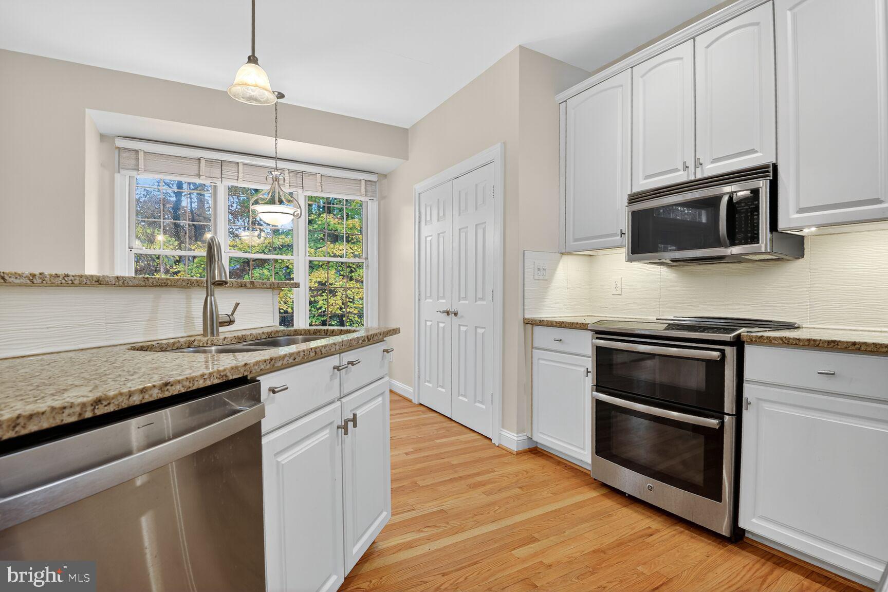 11405 Summer House Court Reston, VA 20194 - Photo 3 of 20 a kitchen with granite countertop wooden cabinets stainless steel appliances and a window