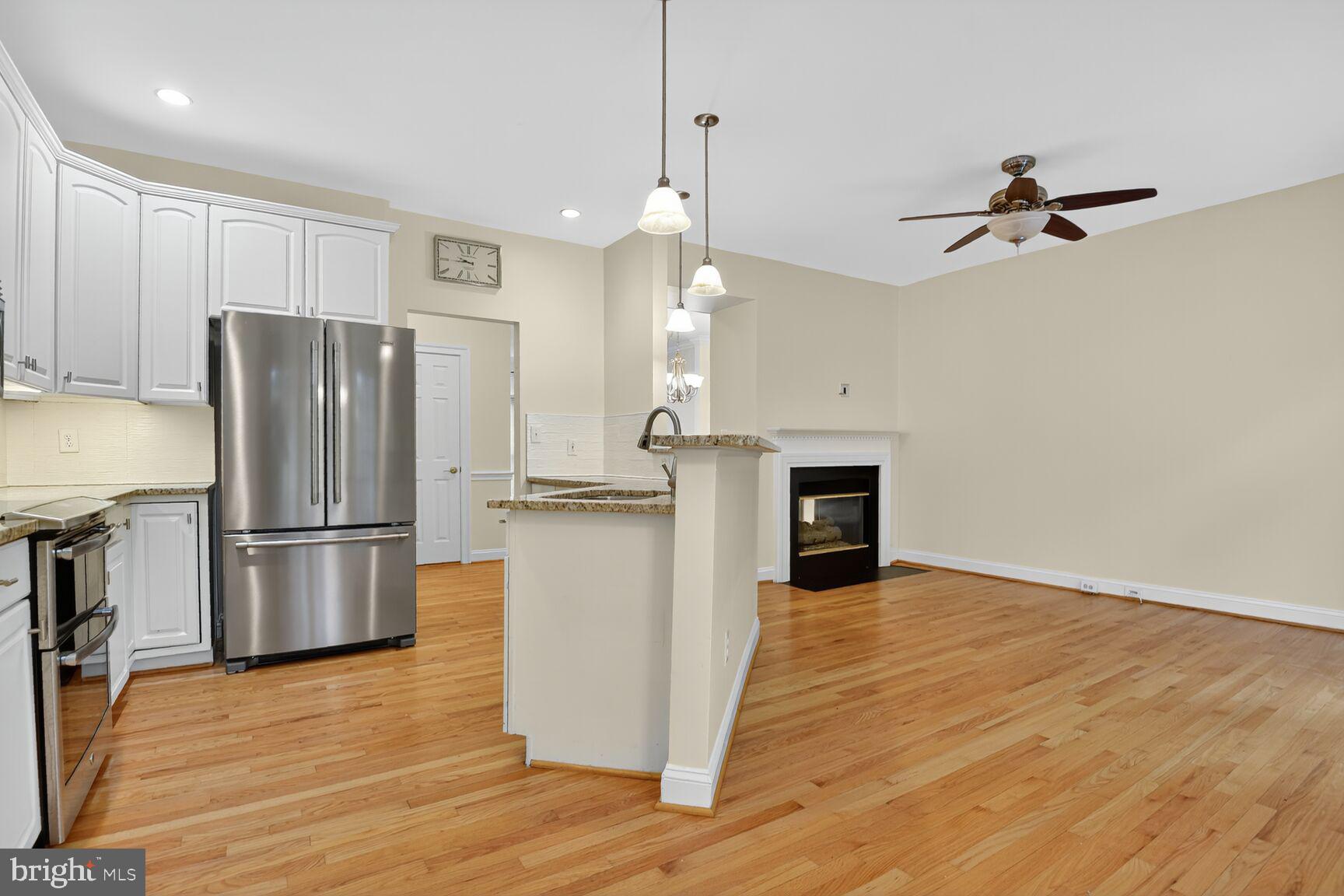 11405 Summer House Court Reston, VA 20194 - Photo 4 of 20 a kitchen with stainless steel appliances a refrigerator a sink and wooden floors