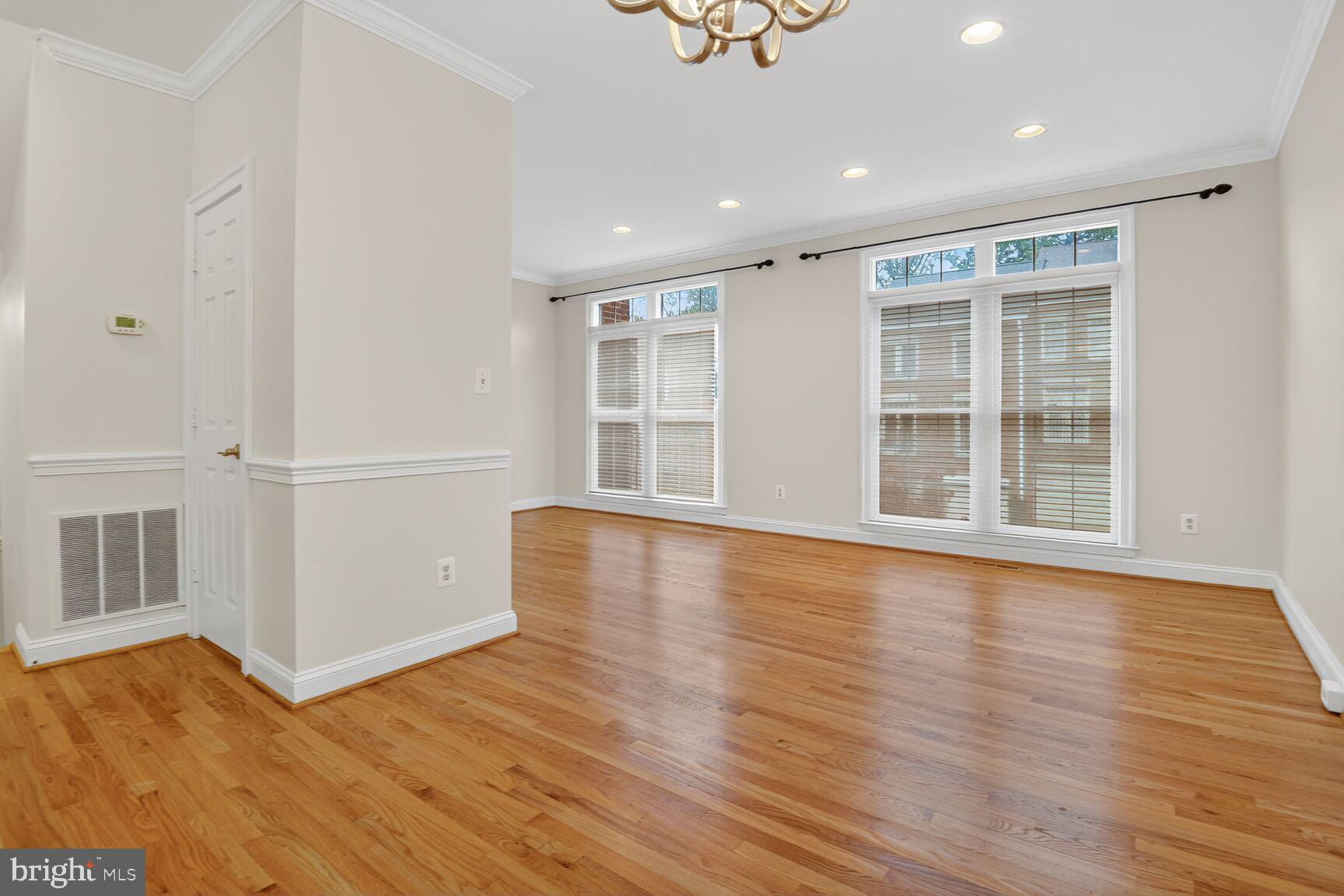 11405 Summer House Court Reston, VA 20194 - Photo 6 of 20 a view of an empty room with wooden floor and windows