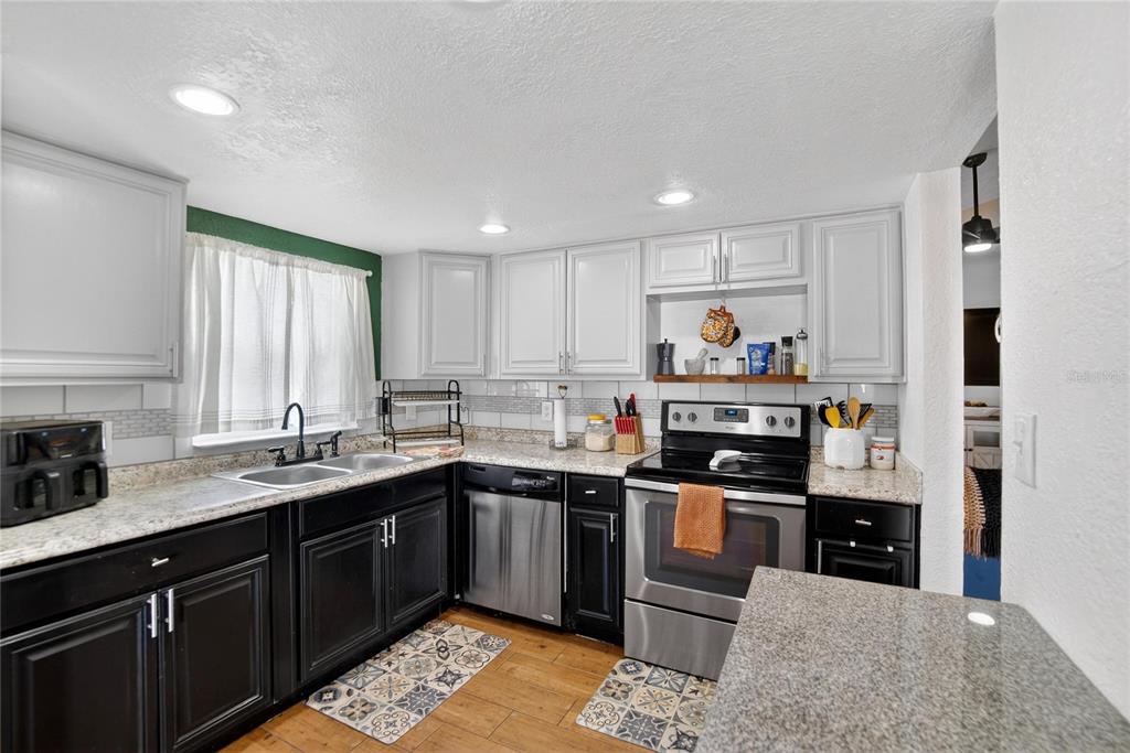 1009 Lenna Avenue Seffner, FL 33584 - Photo 14 of 68 a kitchen with stainless steel appliances granite countertop a sink stove and refrigerator