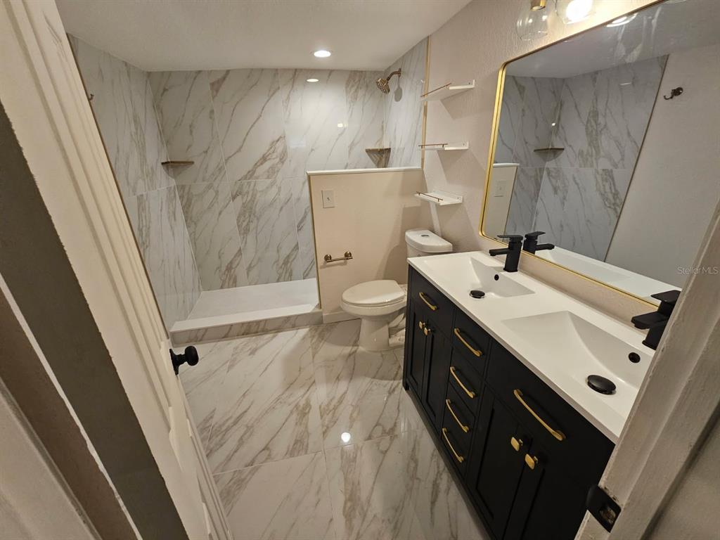 1009 Lenna Avenue Seffner, FL 33584 - Photo 28 of 68 a spacious bathroom with a double vanity sink a toilet and a shower