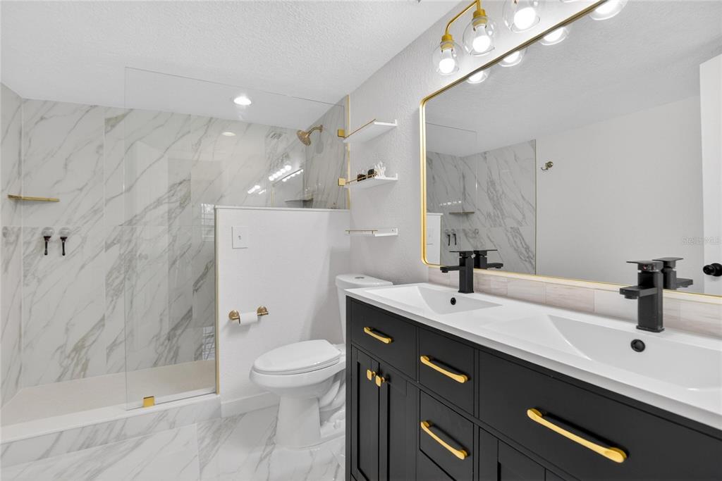 1009 Lenna Avenue Seffner, FL 33584 - Photo 31 of 68 a bathroom with a sink a toilet a mirror and shower