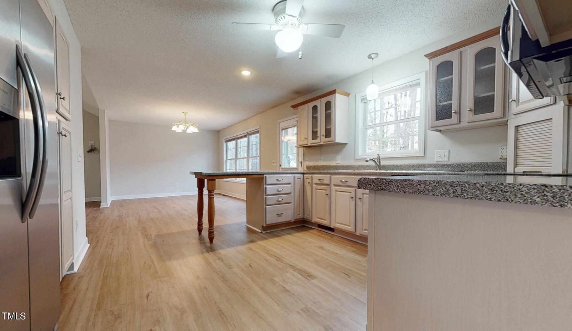 131 Brookfield Circle Sanford, NC 27330 - Photo 16 of 46 a kitchen with stainless steel appliances granite countertop a refrigerator a sink dishwasher a stove and white countertops with wooden floor