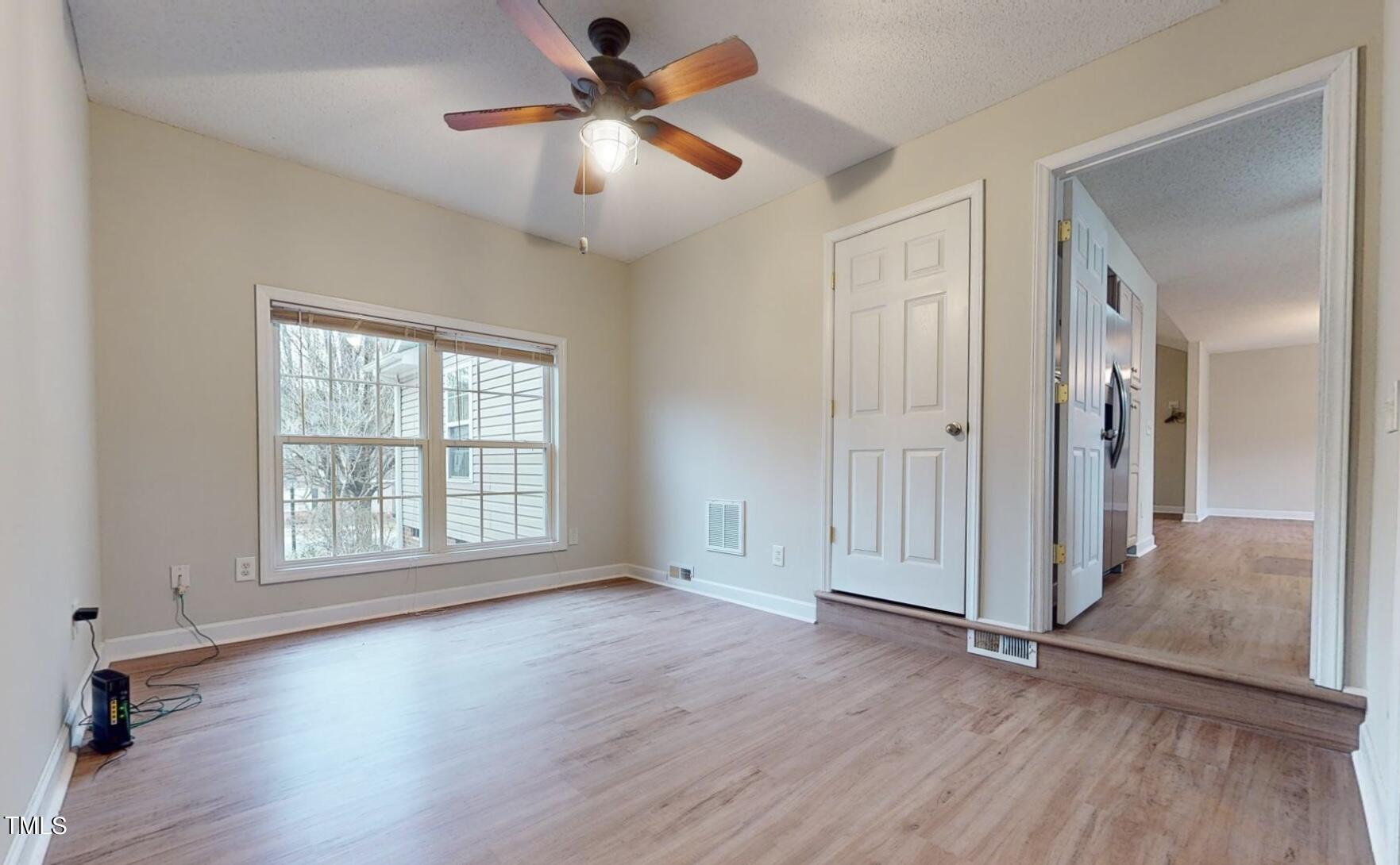 131 Brookfield Circle Sanford, NC 27330 - Photo 34 of 46 an empty room with wooden floor chandelier fan and windows