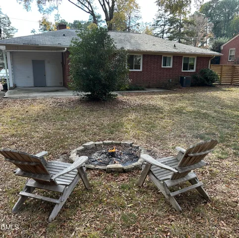 a view of a chairs and table in backyard of a house