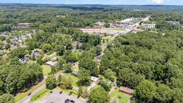an aerial view of residential houses with outdoor space and trees
