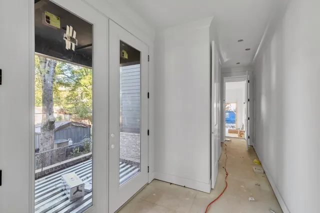 a view of a hallway with wooden floor and a bathroom