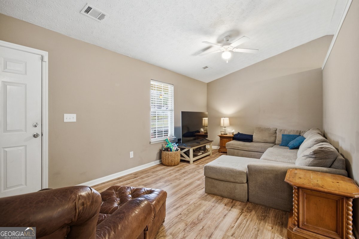 170 Hunters Trace Covington, GA 30014 - Photo 12 of 29 a living room with furniture and a flat screen tv