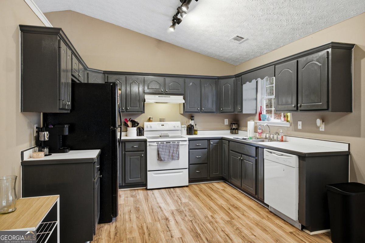 170 Hunters Trace Covington, GA 30014 - Photo 13 of 29 a kitchen with a sink stove and refrigerator