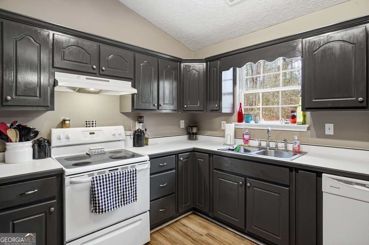 170 Hunters Trace Covington, GA 30014 - Photo 14 of 29 a kitchen with a sink stove and cabinets