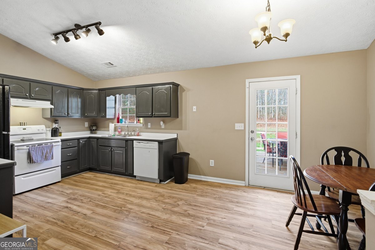 170 Hunters Trace Covington, GA 30014 - Photo 15 of 29 a kitchen with a table chairs a sink dishwasher a refrigerator and microwave