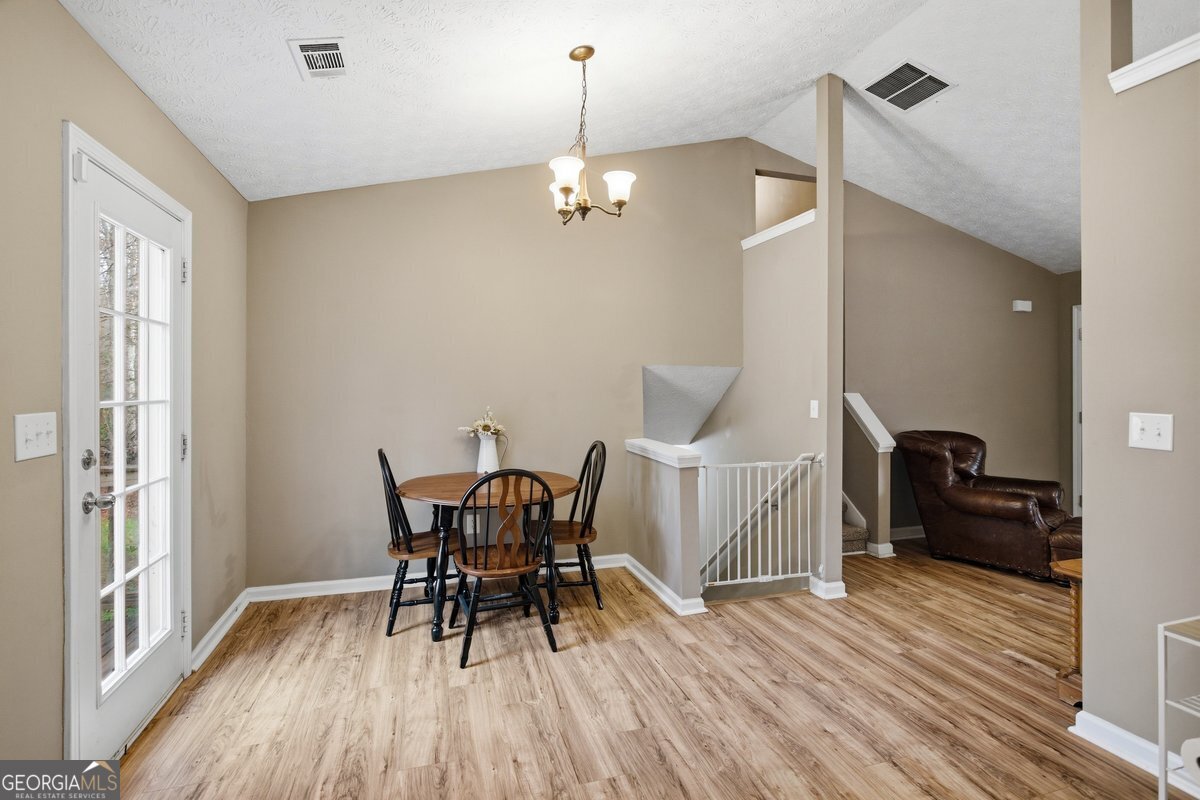 170 Hunters Trace Covington, GA 30014 - Photo 16 of 29 a view of a dining room with furniture a chandelier and wooden floor