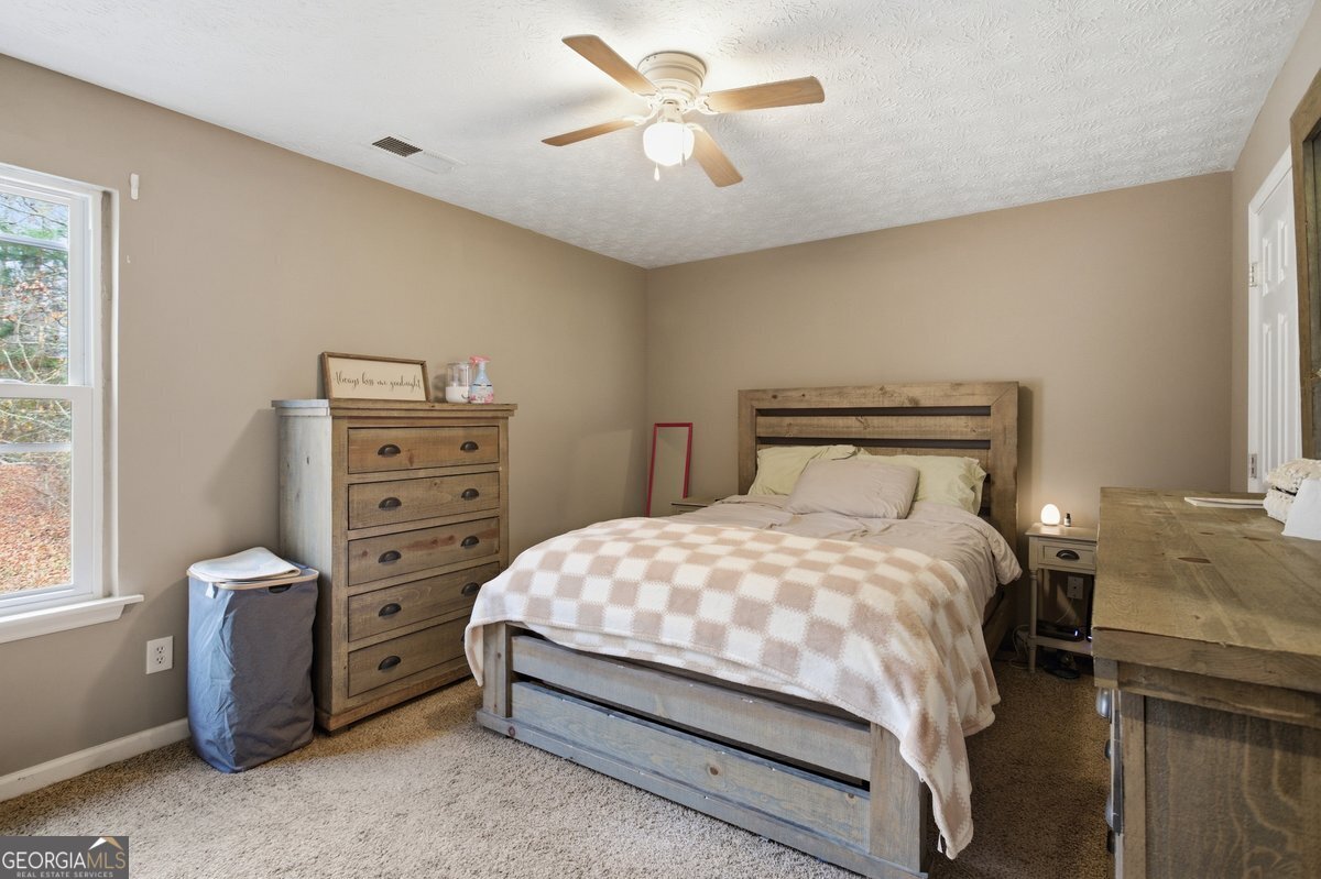 170 Hunters Trace Covington, GA 30014 - Photo 17 of 29 a bedroom with a bed and a ceiling fan