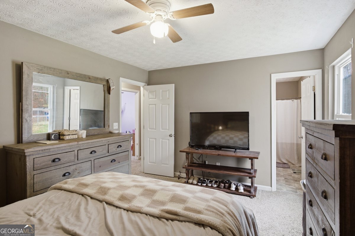 170 Hunters Trace Covington, GA 30014 - Photo 18 of 29 a bedroom with a bed and a flat screen tv on dresser