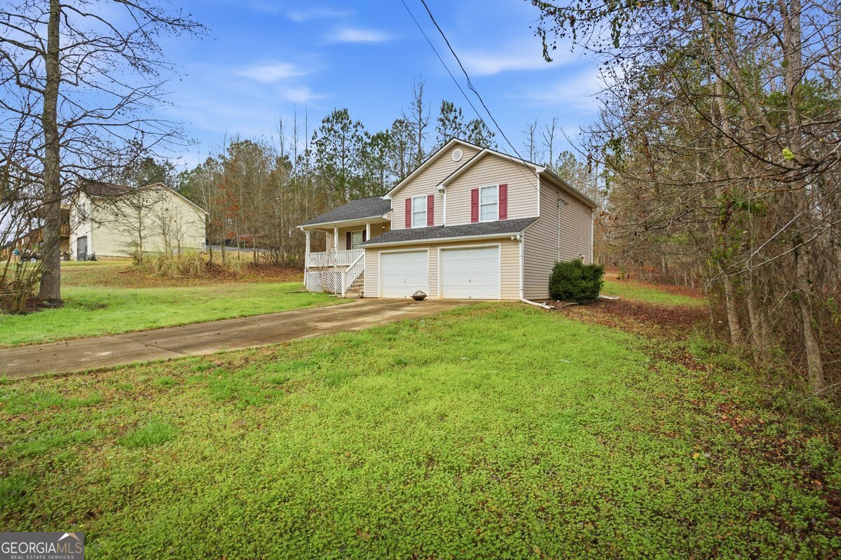 170 Hunters Trace Covington, GA 30014 - Photo 2 of 29 a front view of a house with a yard and garage