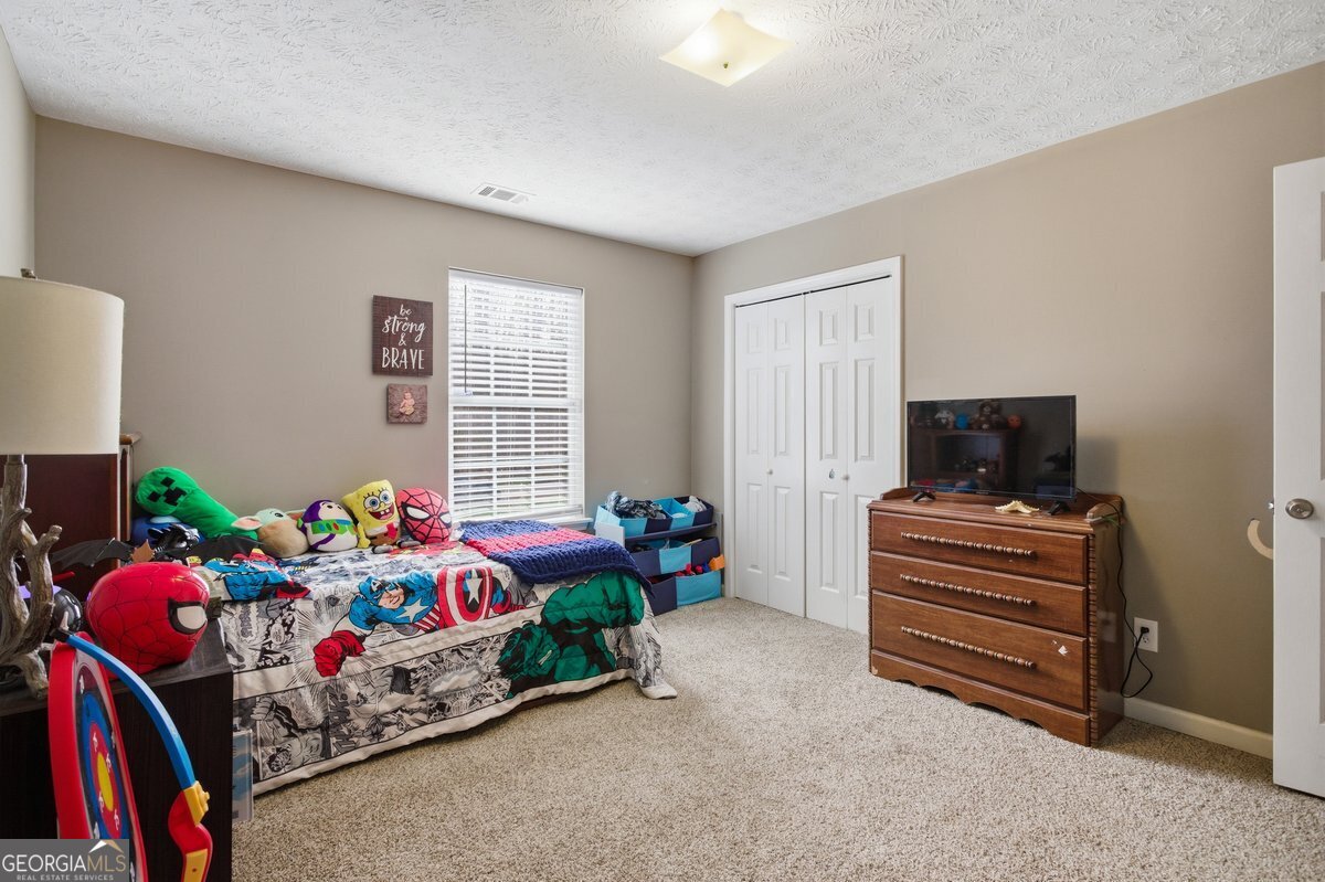 170 Hunters Trace Covington, GA 30014 - Photo 21 of 29 a bedroom with furniture and a bed