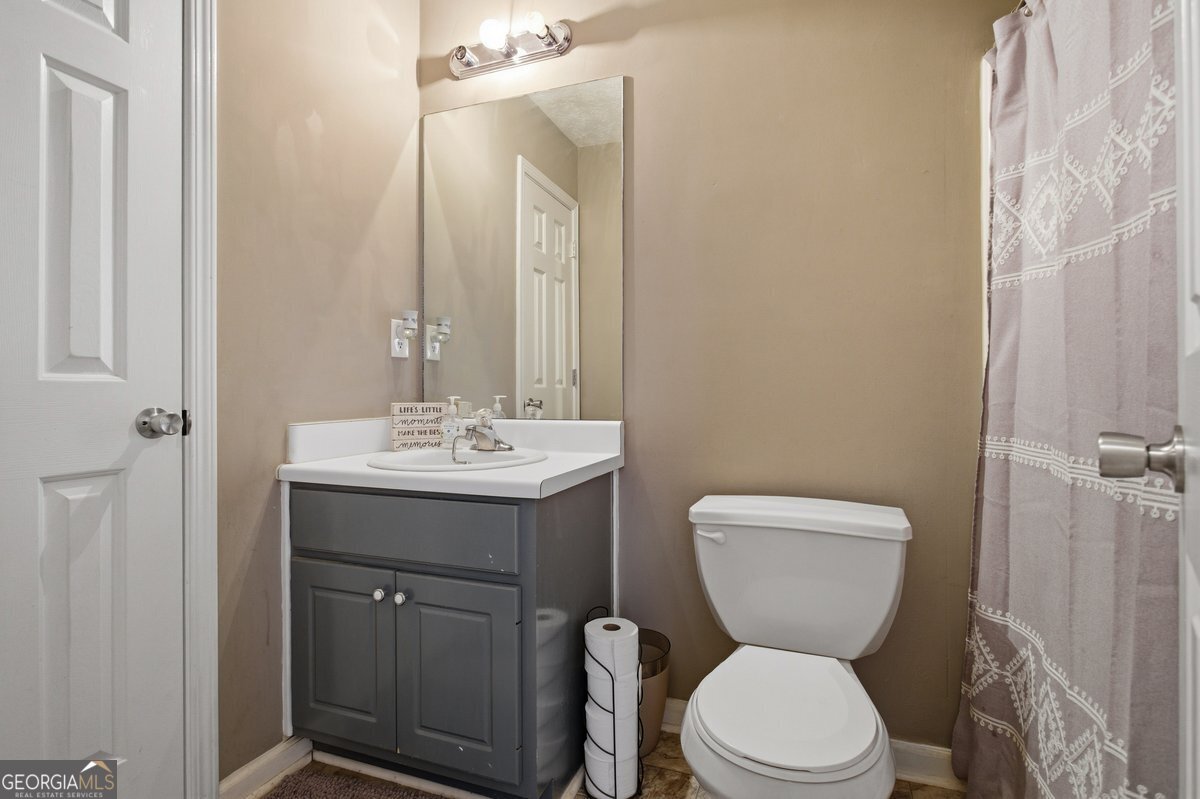 170 Hunters Trace Covington, GA 30014 - Photo 22 of 29 a bathroom with a toilet sink and mirror