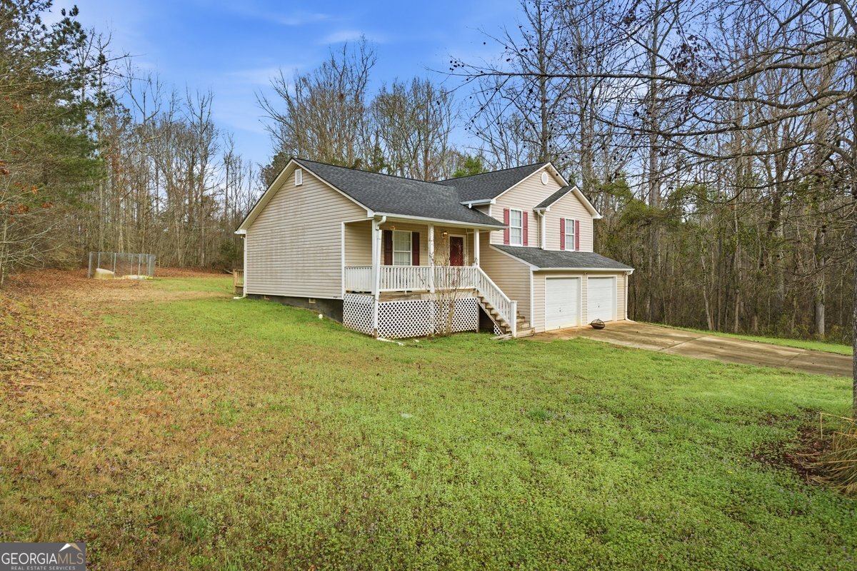 170 Hunters Trace Covington, GA 30014 - Photo 3 of 29 a front view of a house with a garden and trees