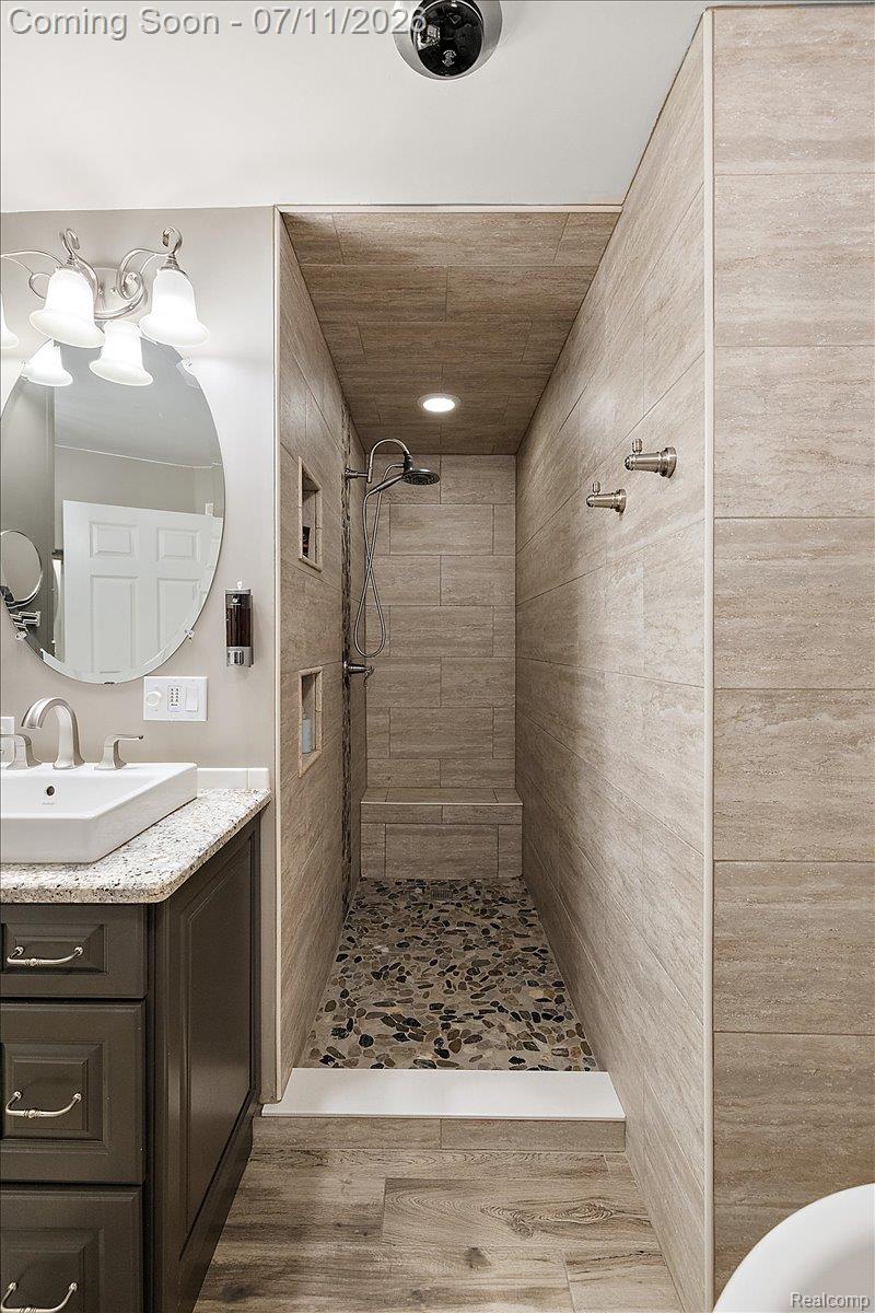 4219 Gardner Road Metamora, MI 48455 - Photo 27 of 87 Walk-in shower featuring pebble-finish flooring, a built-in bench, and recessed shelving