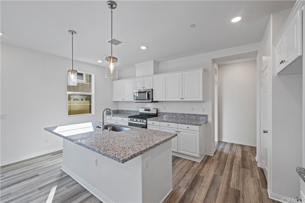 1752 Apricot Tree Place Upland, CA 91784 - Photo 7 of 23 a kitchen with kitchen island granite countertop wooden cabinets a stove a sink and a granite counter tops