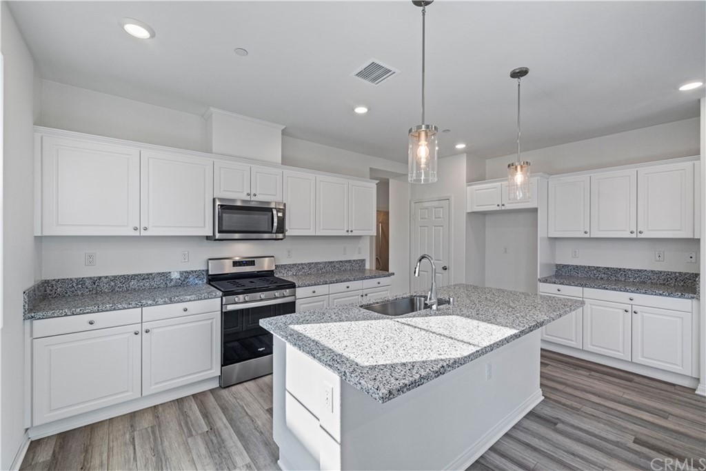 1752 Apricot Tree Place Upland, CA 91784 - Photo 8 of 23 a kitchen with granite countertop a sink a counter top space stainless steel appliances and cabinets