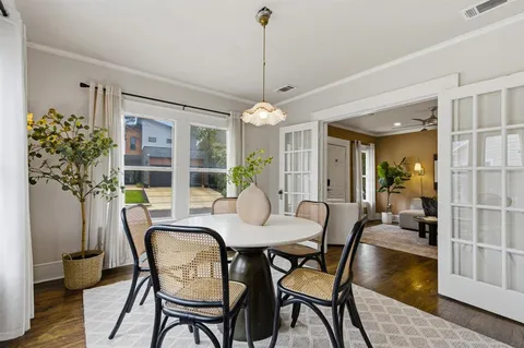 a dining room with furniture a chandelier and wooden floor