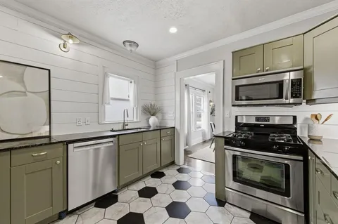 a kitchen with stainless steel appliances granite countertop a stove top oven microwave and cabinets