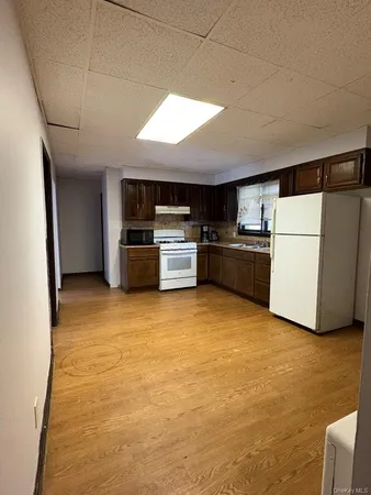 a kitchen with a refrigerator and a stove top oven