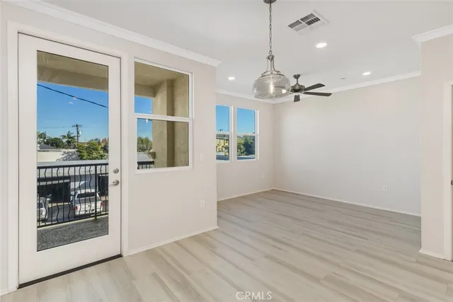 an empty room with wooden floor mirror and windows