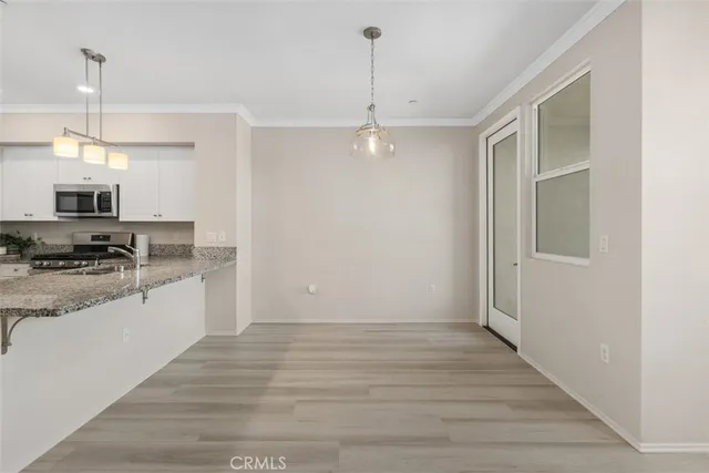 a kitchen with granite countertop a stove a sink and a refrigerator
