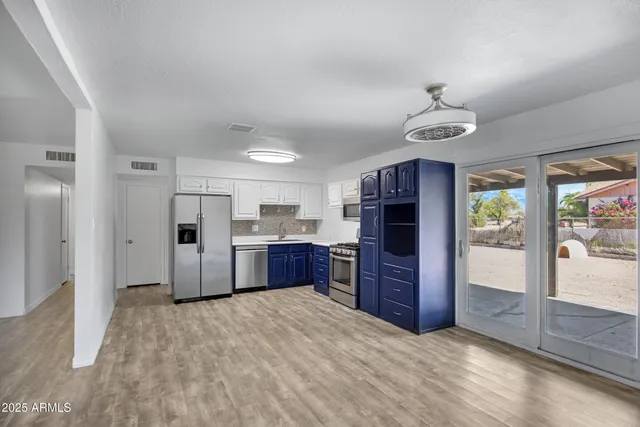 a kitchen with stainless steel appliances kitchen island granite countertop a refrigerator and a stove top oven