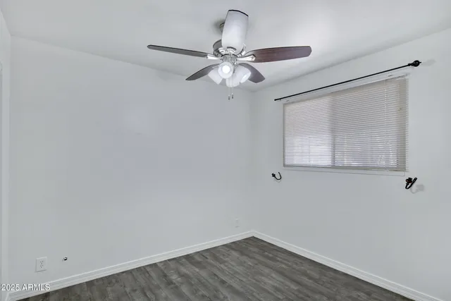 a view of a small space with wooden floor and a ceiling fan