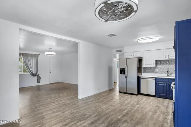 a view of kitchen with stainless steel appliances granite countertop a refrigerator and a stove top oven