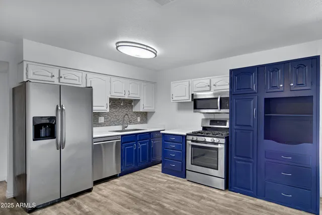 a kitchen with stainless steel appliances granite countertop a refrigerator stove and sink