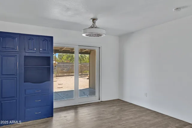 an empty room with windows and cabinet