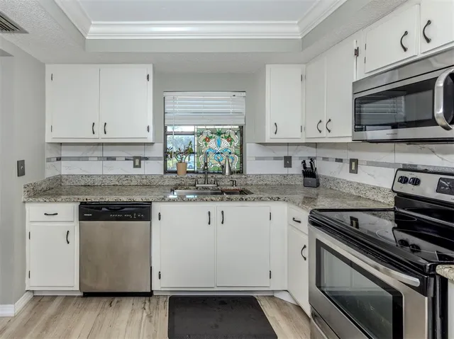 a kitchen with granite countertop a stove and a microwave