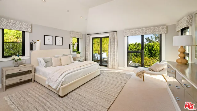 a bedroom with a large bed and a large window