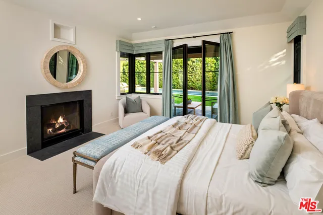 a bedroom with a large bed and a fireplace