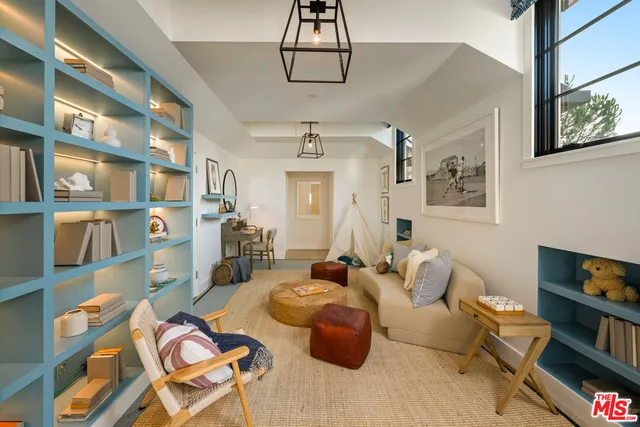 a living room with furniture a flat screen tv and bookshelf