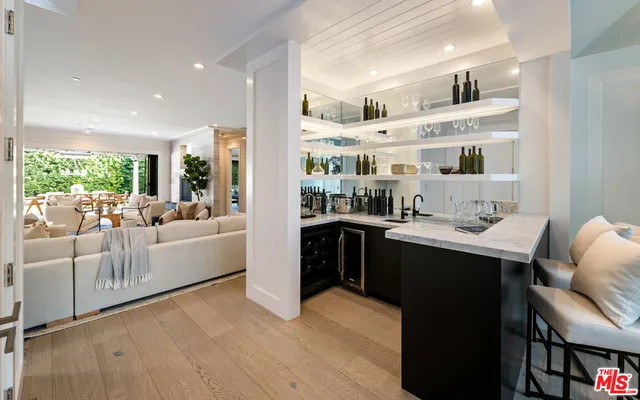 a large living room with stainless steel appliances kitchen island granite countertop a sink and wooden floor