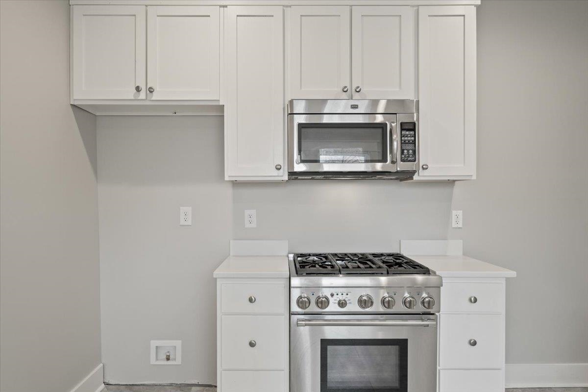 598 Spring Street Memphis, TN 38112 - Photo 12 of 29 a kitchen with white cabinets and appliances
