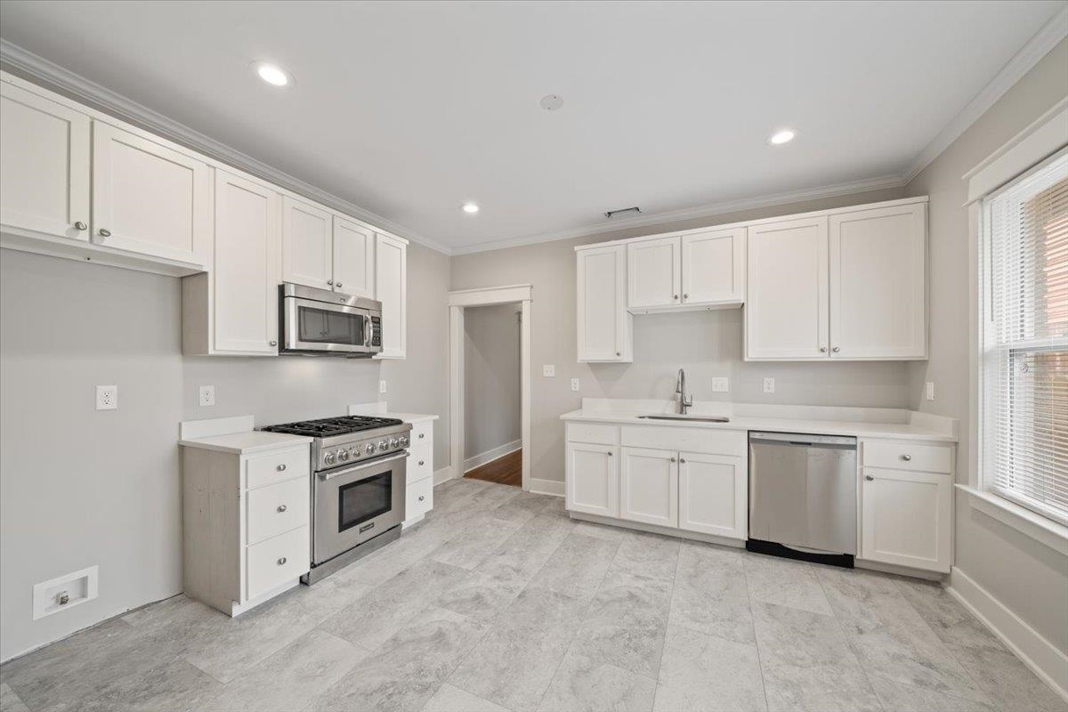 598 Spring Street Memphis, TN 38112 - Photo 13 of 29 a kitchen with granite countertop white cabinets and white appliances