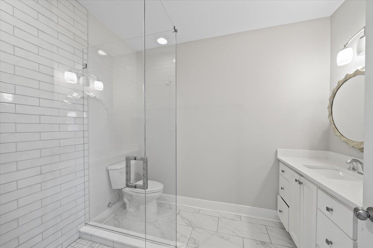 598 Spring Street Memphis, TN 38112 - Photo 15 of 29 a bathroom with a double vanity sink toilet and a mirror