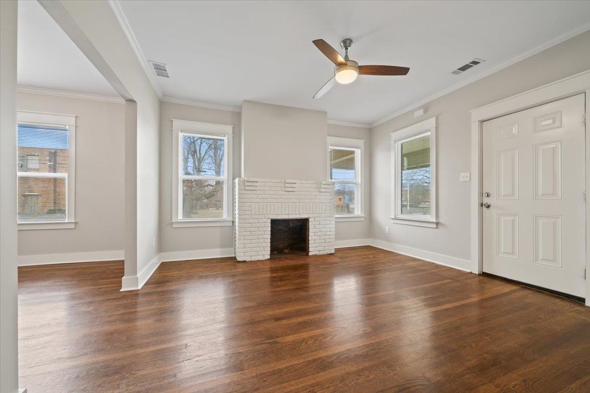 598 Spring Street Memphis, TN 38112 - Photo 5 of 29 an empty room with wooden floor a ceiling fan and windows