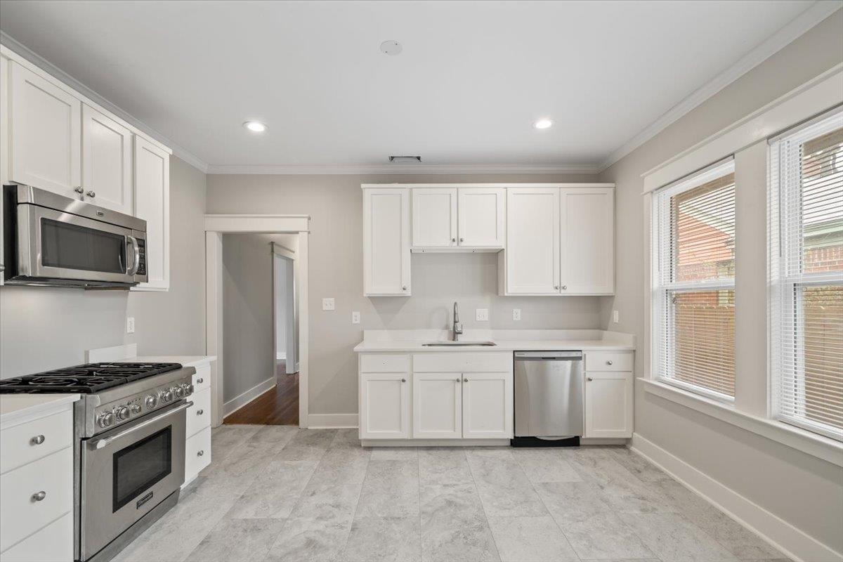 598 Spring Street Memphis, TN 38112 - Photo 9 of 29 a kitchen with white cabinets and appliances