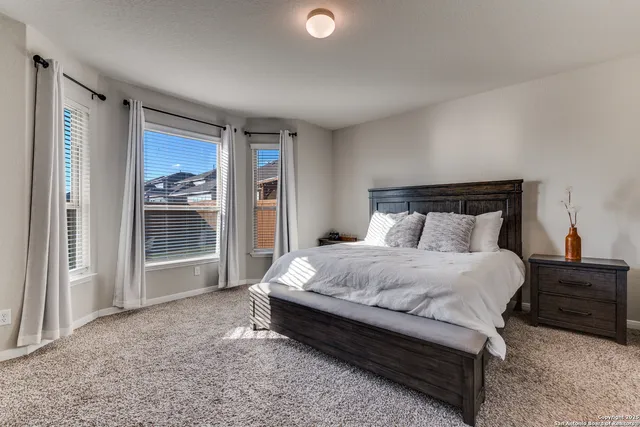 a large bed sitting in a bedroom next to a window and a larger closet