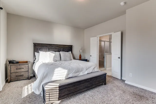 a bed sitting in a bedroom next to a window and dresser