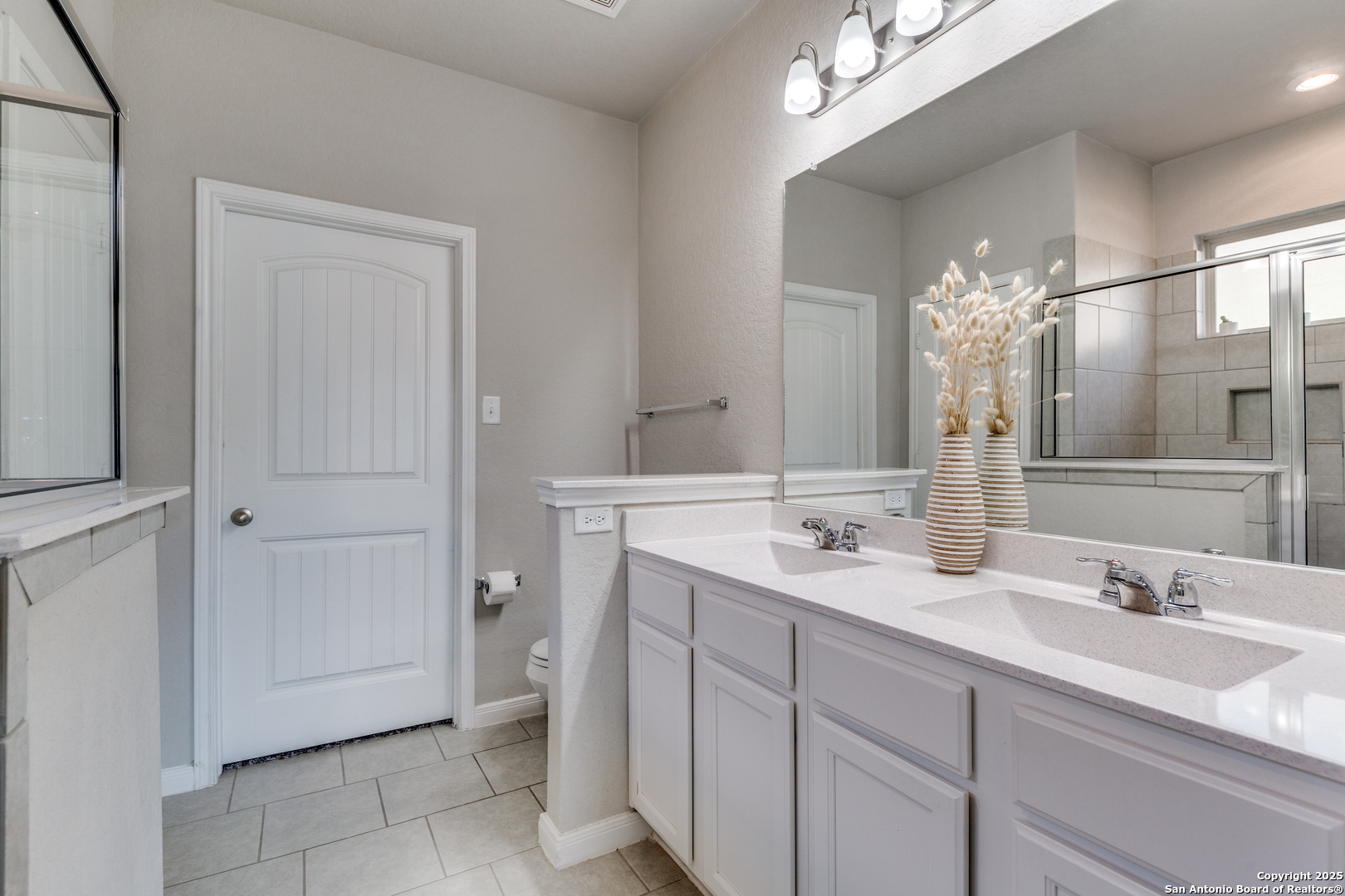 4807 Marylebone Avenue Converse, TX 78109 - Photo 14 of 25 a spacious bathroom with a double vanity sink a mirror and a shower