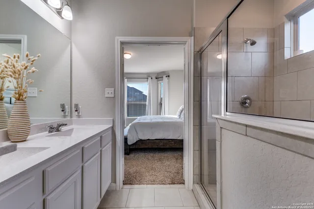 a en suite bathroom with a double vanity sink a large mirror and shower